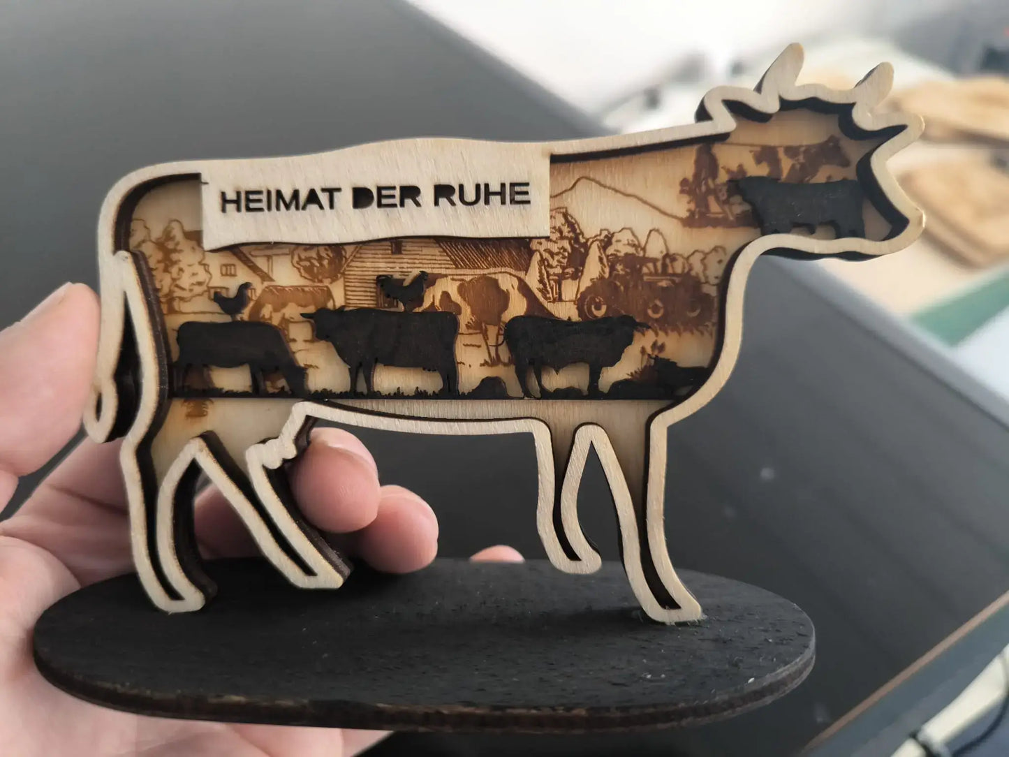 Personalisierte Holzdeko bayerische Kuh mit eingearbeitetem Landschaftsdesign und Schriftzug Heimat der Ruhe