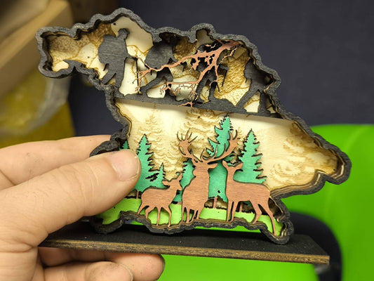 3D Holzdeko Hirsch mit farbigen Details und stilisierten Waldmotiven in Hand gehalten
