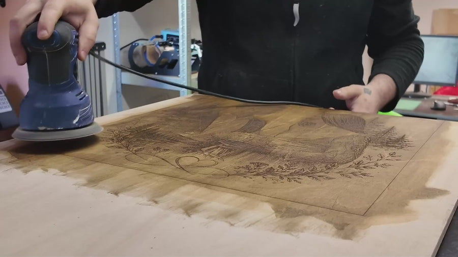 Feinschliff eines gravierten Holzbilds von Hand mit einem Exzenterschleifer in der KözArtDesign-Werkstatt in Bad Kötzting.